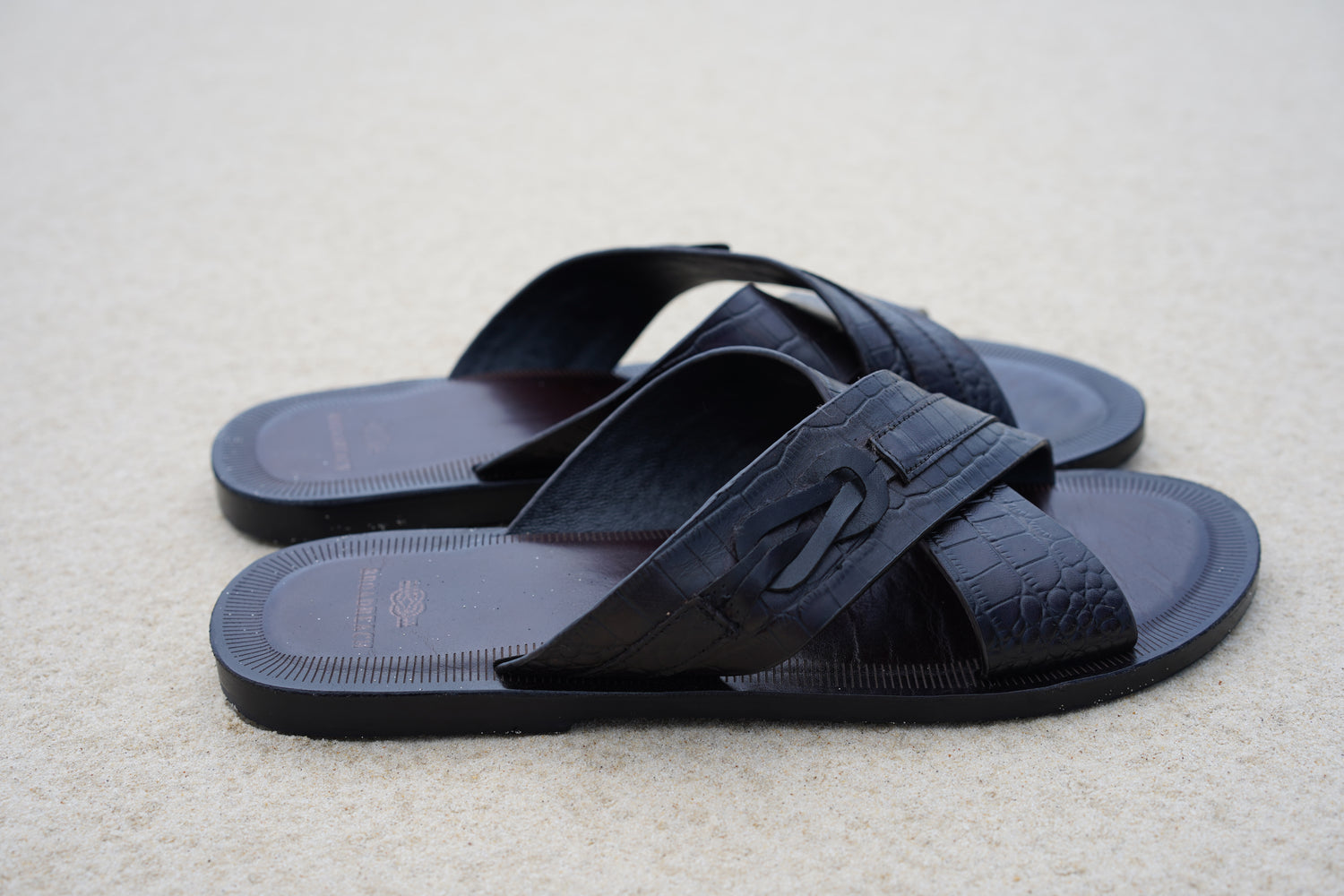 Image of men’s leather Lagoon sandals by BroadReach resort wear against sand backdrop.